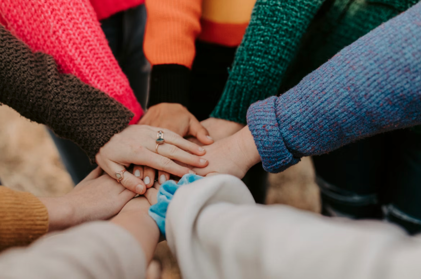 Community members joining hands together